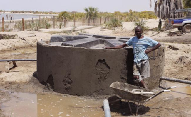 A man building a water tank in Kenya