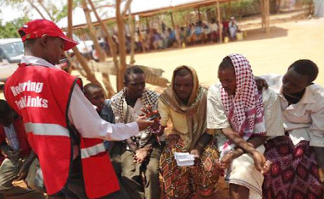 One of the four refugee camps in Dadaab, Kenya. A KRCS volunteer helps a refugee