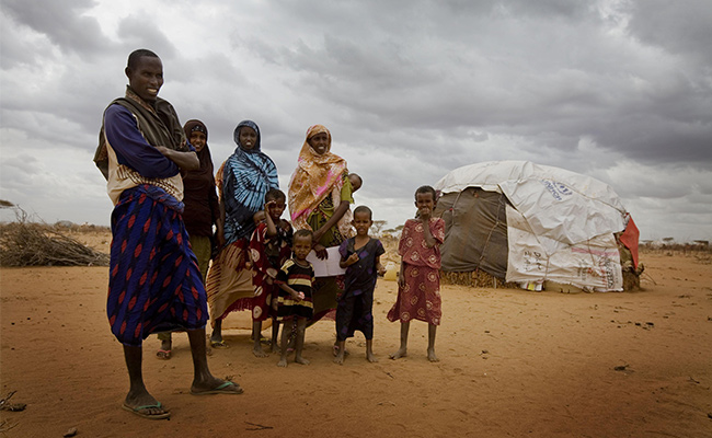 Osman and his family stand in front of their make shift home