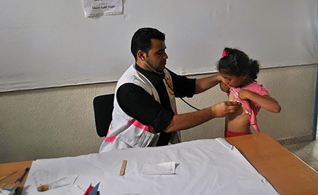 Dr Ghassan Qaraman examines a girl at a mobile health clinic in Gaza