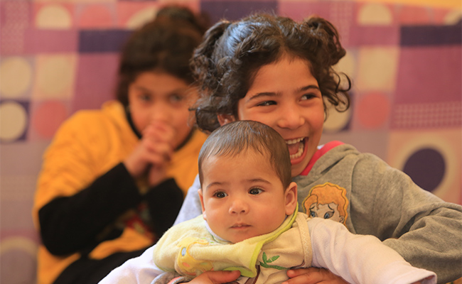 Baby Adil and sister. Photo: Ibrahim Malla/ British Red Cross