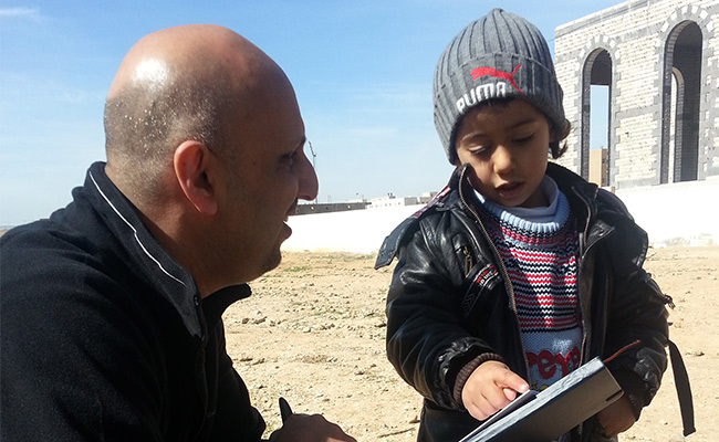 Syrian refugee child showing Saleh Saeed directions