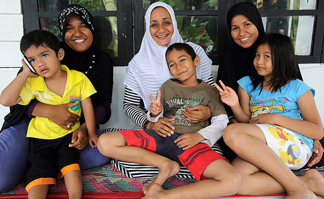 Sisters Noni, Nona & Nina (with their children) in front of their rebuilt home which was originally destroyed by the tsunami