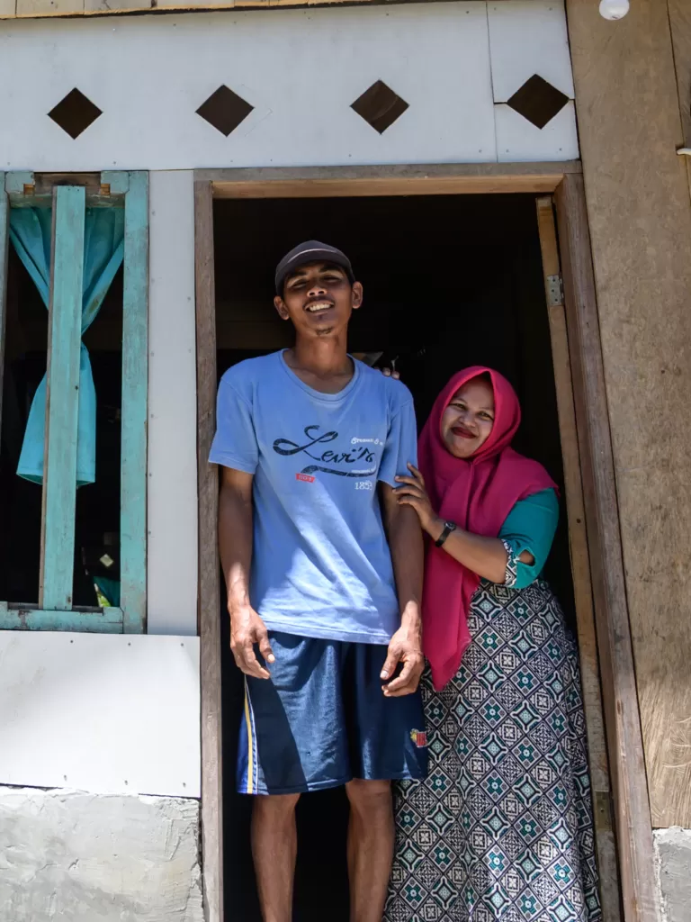 A man and woman stand in the entrance to a house