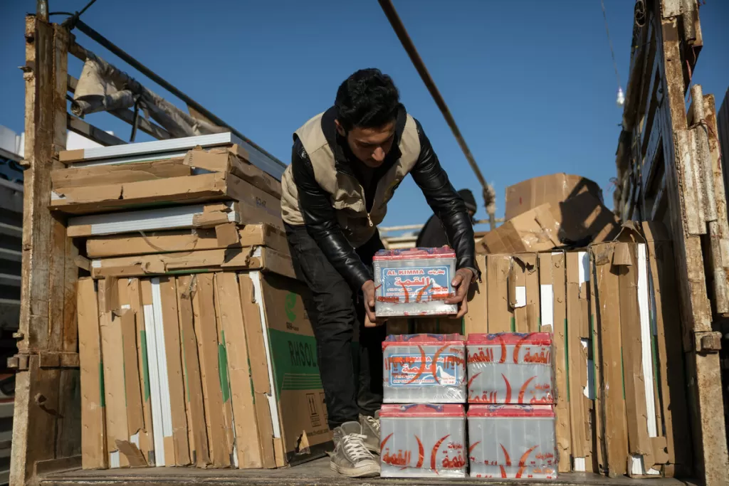 Farug* sorts through the aid outside a camp in Northwest Syria on the 14th February 2023
